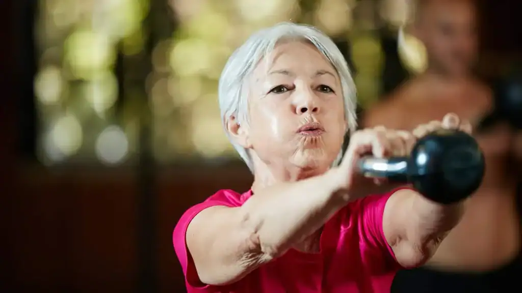 Toning Arms After 60: Empowering Womens Fitness Through Effective Weight Training 1 Older woman doing weight training Daventry to help her strength and longevity