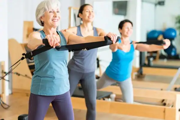 Toning Arms After 60: Empowering Womens Fitness Through Effective Weight Training 2 older woman doing weight training Daventry and resistance in the gym to tone upper arms