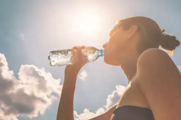 Hydration: The Secret Ingredient for a Toned Stomach and Enhanced Fitness 3 Image of woman drinking water to hydrate Daventry after run.